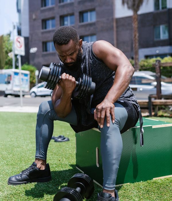 Man performing a controlled bodyweight exercise in a minimalist gym setting.